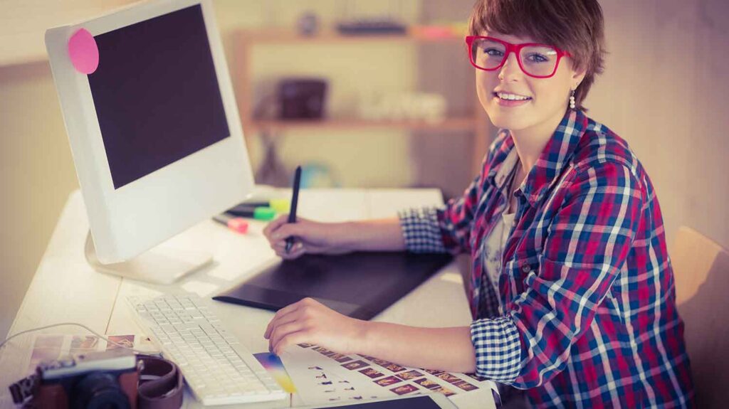 young women looking at camera behind her desk