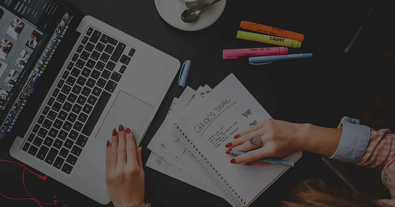 A woman taking notes in front of her laptop
