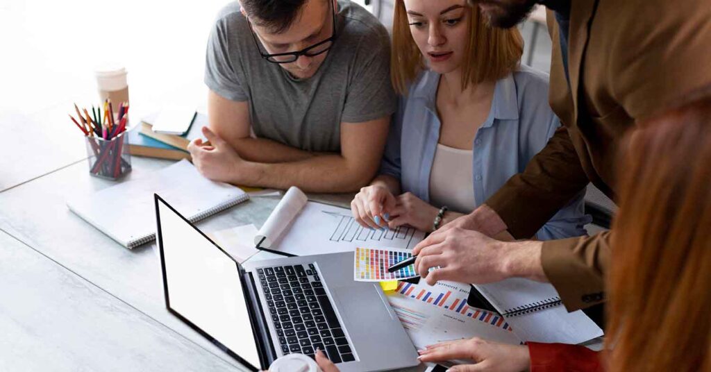4 people around a laptop learning about color palettes